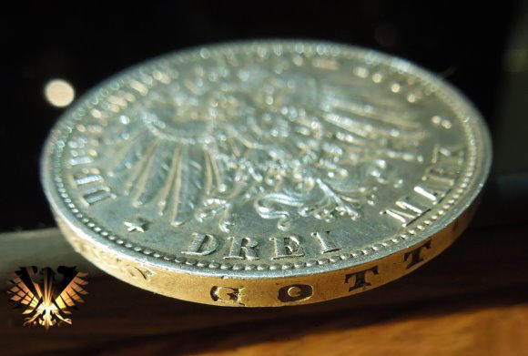 Detailansich vom Rand der drei Mark Silbermünze aus dem deutschen Kaiserreich. Der Rand ist Glatt und trägt die Inschrift: GOTT MIT UNS.