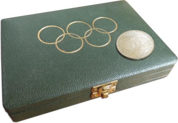 Aufsicht auf das Etui der Münchner Sommerolympiade 1972 in München. Auf dem Deckel das Logo, die 5 Olympischen Ringe.
