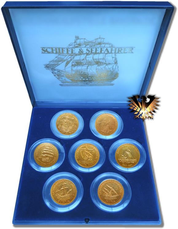Die in blauem Samt ausgeschlagene Schmuckbox mit allen 7 vergoldeten Sammlermünzen der Serie Schiffe & Seefahrt aus Kuba. Zu sehen sind die Schiffe Santa Maria, Nina & Pinta, die Darstellung eines KON-TIKI Floßes und das Kriegsschiff Santissima Trinidad.